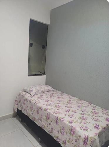 a small bed in a bedroom with a mirror at Espaço amplo e privativo in Trindade