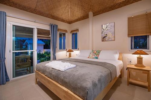 a bedroom with a bed and a large window at The Hidden Lagoon in Rawai Beach