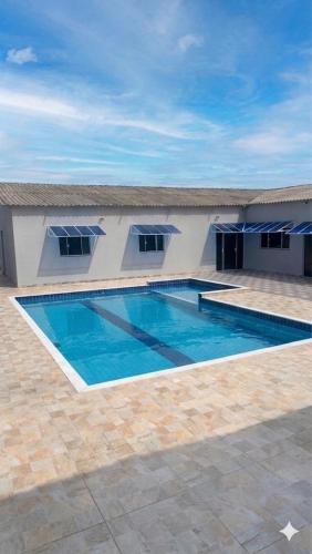 a swimming pool in front of a building at Casa Espaçosa com Piscina, 4 Quartos e Ar-Condicionado in Itanhaém