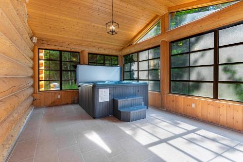 a screened in porch with windows and a jacuzzi at Fiddler Lake Resort - Moose 46 in Mille-Isles