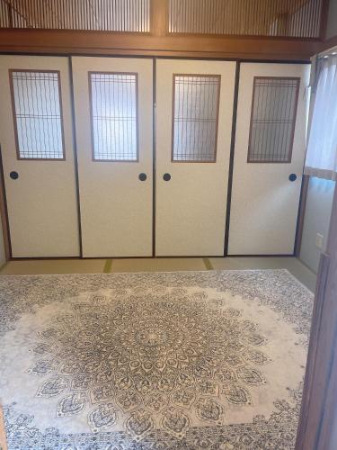 a room with three doors and a rug at 桃谷民宿 in Osaka