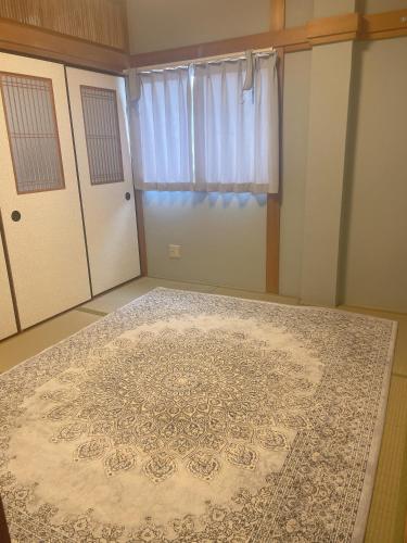 a room with a rug on the floor next to doors at 桃谷民宿 in Osaka