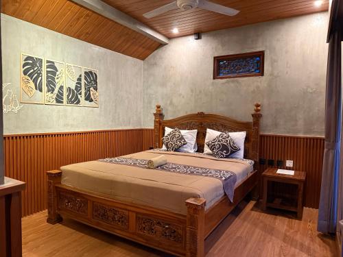 a bedroom with a wooden bed in a room at Eka's Homestay in Ubud