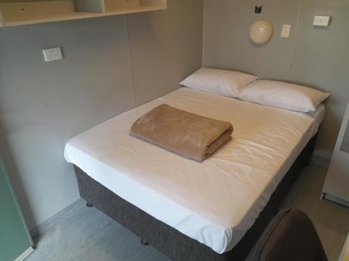 a bed with a brown blanket on top of it at Cheap Rooms North Brisbane in Narangba