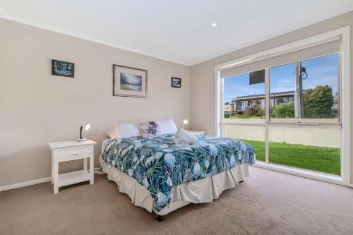 a bedroom with a bed and a large window at The Dunes 1 - BYO Linen in Apollo Bay