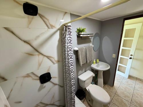 a bathroom with a toilet and a sink at Brisa Del Mar in Playa Hermosa