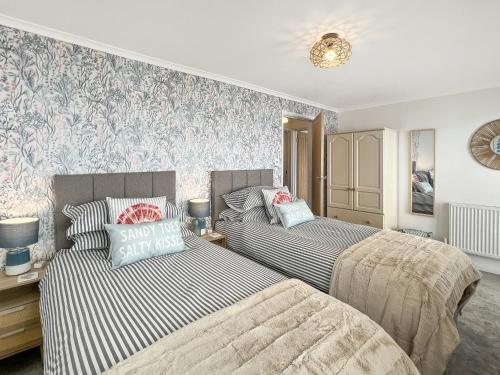 a bedroom with two beds and a wall mural at Beach View Cottage Minehead in Minehead
