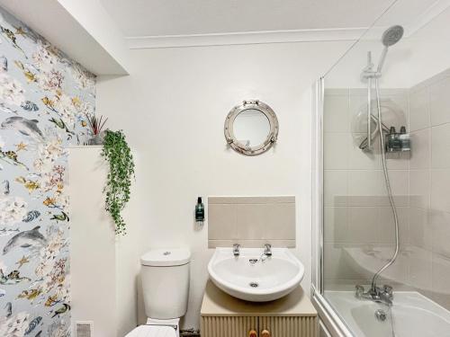 a bathroom with a toilet and a sink and a shower at Beach View Cottage Minehead in Minehead