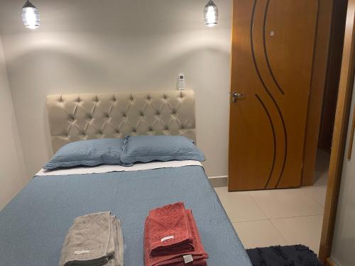 a bedroom with a bed with two towels on it at Royal Lion Bedroom in Londrina