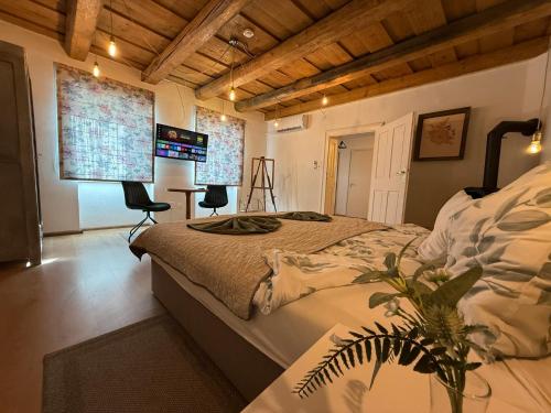 a bedroom with a large bed and two windows at Corte Apartman in Pápa