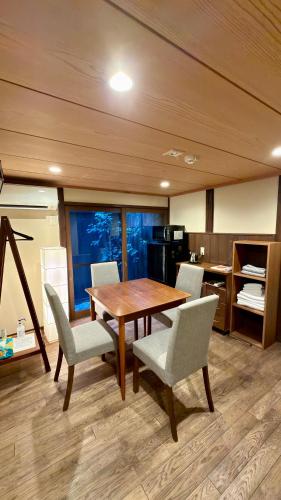 a dining room with a wooden table and chairs at Kyoto Gion No Yado in Kyoto