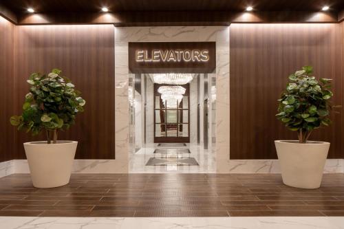 a lobby with two potted plants and a sign at Live Casino & Hotel Louisiana, Curio Collection by Hilton in Bossier City