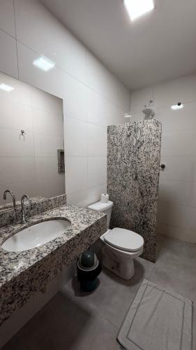 a bathroom with a sink and a toilet at Hotel Estrela de Minas in São Gabriel