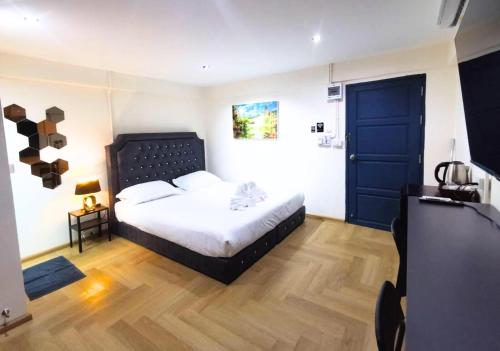 a bedroom with a bed and a blue door at The One Hotel in Pattaya