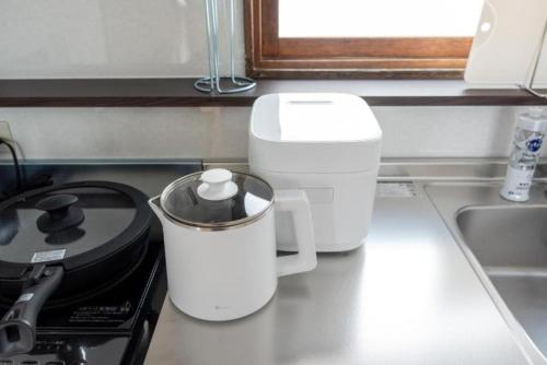 a kitchen counter with a coffee maker on a stove at Biei Relax Stay B in Biei
