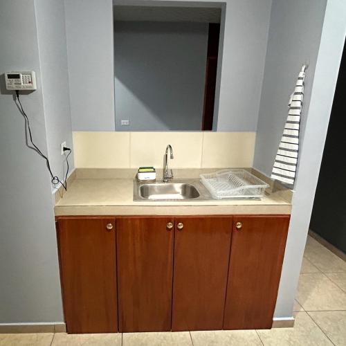 a kitchen with a sink and a mirror at Oasis House 1 in Cabuya