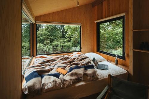 a bed in a room with two windows at awake Gojome in Akita