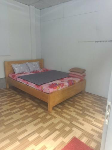 a bed in a room with a wooden floor at Homestay Phố biển cam bình in Lagi