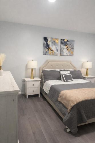 a bedroom with a bed and two night stands and two lamps at Chic & Comfy Apartment in Elizabethport