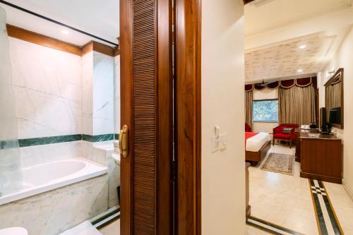 a bathroom with a tub and a sink at Hotel Kwality Regency in Chandīgarh