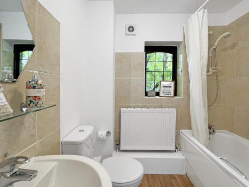 a bathroom with a toilet and a sink and a tub at Stables Cottage Ellicombe in Minehead