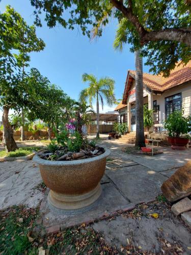 a large stone planter in front of a house at Homestay Phố biển cam bình in Lagi