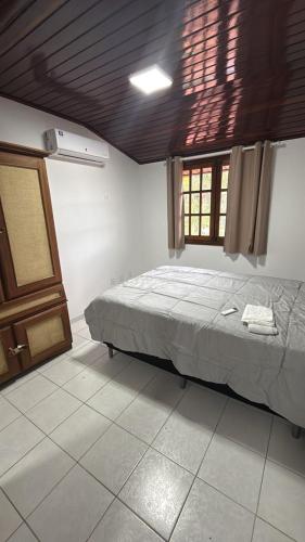 a bedroom with a bed in a room with a window at Privê Refúgio Gravatá in Gravatá