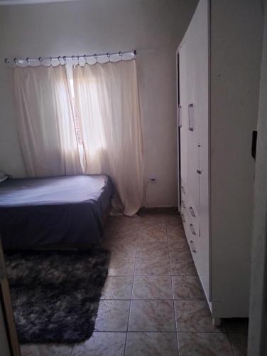 a small bedroom with a bed and a window at Quarto casal com banheiro in Sao Jose do Rio Preto