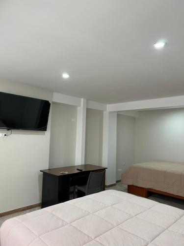a bedroom with a bed and a desk and a tv at Hotel Altavista in Abancay