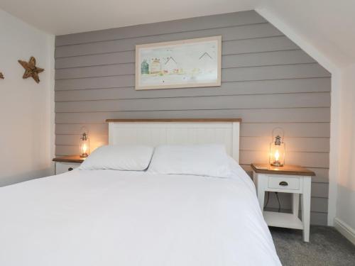 a bedroom with a white bed and two night stands at Coastal Cottage in Reighton