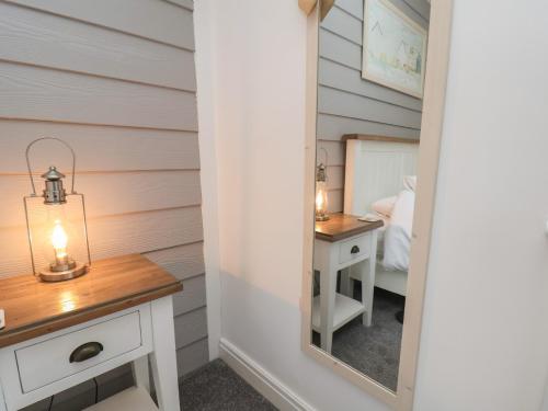 a room with a mirror and a vanity with a bed at Coastal Cottage in Reighton