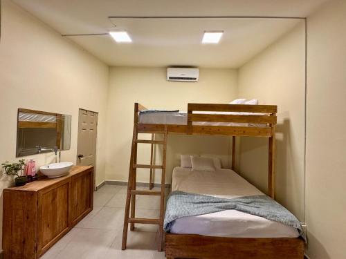 a bedroom with a bunk bed and a sink at Islas Boho Tiny Home - Main strip El Tunco in El Sunzal
