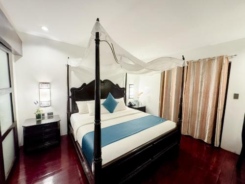 a bedroom with a bed with a canopy at Boracay Summer Palace Hotel in Boracay