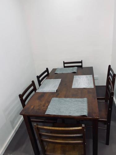 ein Holztisch mit vier Stühlen darum herum in der Unterkunft 4scape BnB in Mba
