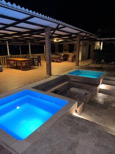 two swimming pools in a patio at night at Ecohotel Naranjos in Jenesano