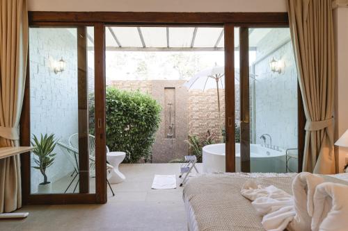 a bathroom with a tub and a bed in a room at Unique Lanna Style Spa Pool Villa in Chiang Mai