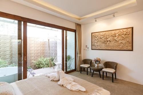 a bedroom with a bed and a tub and a table at Unique Lanna Style Spa Pool Villa in Chiang Mai