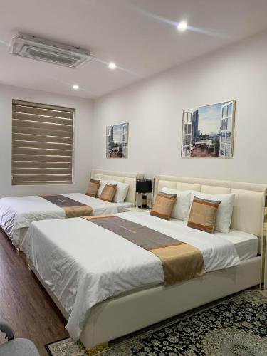 two beds in a white room with two bedsvisor at Khách sạn Thy Thảo 3 in Ho Chi Minh City