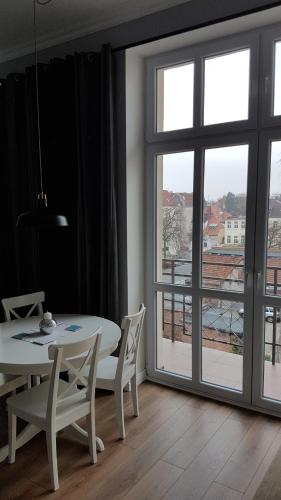 jadalnia ze stołem i krzesłami oraz oknem w obiekcie Przy Poli Negri w Bydgoszczy