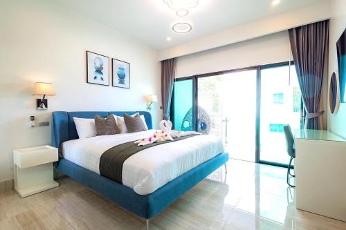a bedroom with a blue bed and a large window at Koh Chang Luxury Pool Villas in Ko Chang