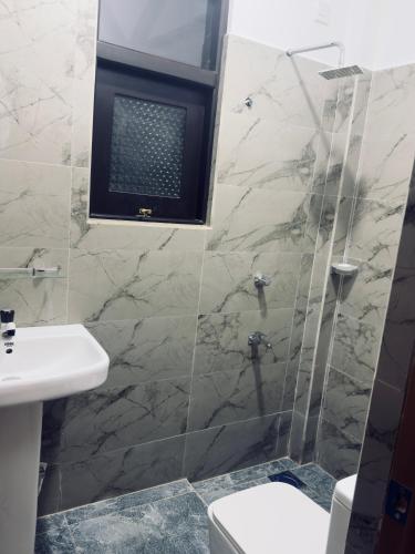 a bathroom with a shower and a toilet and a sink at Ancestral Aura in Negombo