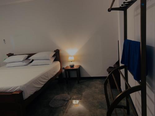 a bedroom with a bed and a table with a lamp at Ancestral Aura in Negombo