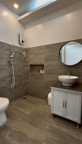 a bathroom with a sink and a toilet and a mirror at Speranza Hotel & Restaurant in Infanta
