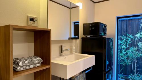 a bathroom with a white sink and a mirror at Kyoto Gion No Yado in Kyoto