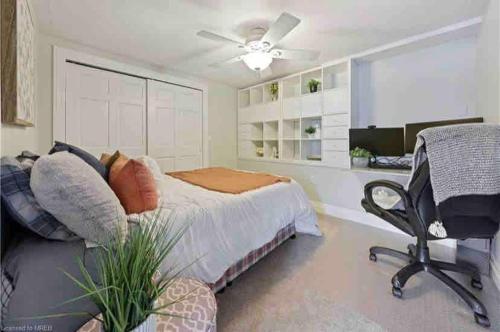 a bedroom with a bed and a desk and a chair at Cozy cottage on the River in Port Dover