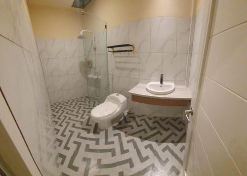 a bathroom with a toilet and a sink at Hotel & Resto Marza 88 in Pangkajene