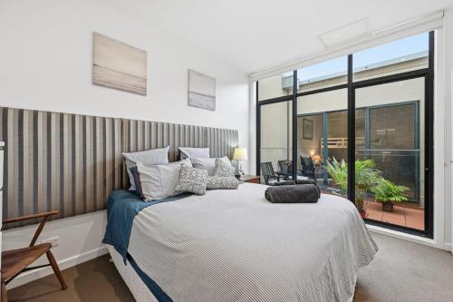 a bedroom with a large bed and a large window at Tide & Town - Perfectly Located! in Inverloch