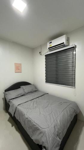 a bedroom with a bed and a window with a heater at Solara Villa, Gensan in General Santos