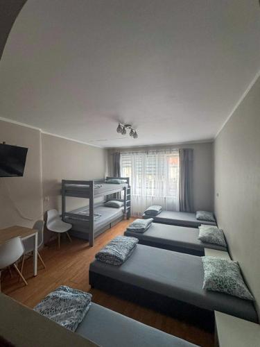 a room with four beds in it with a window at Żeromskiego 2024 in Gdynia
