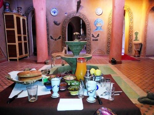 a table with a fountain with food and drinks at Kasbah Les Alizes Du Desert in Mhamid